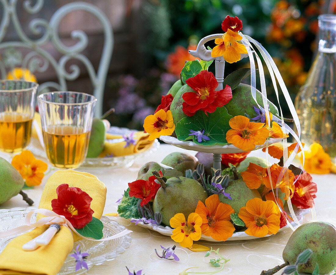 Spätsommerliche Tischdekoration mit Kapuzinerkresse und Früchten