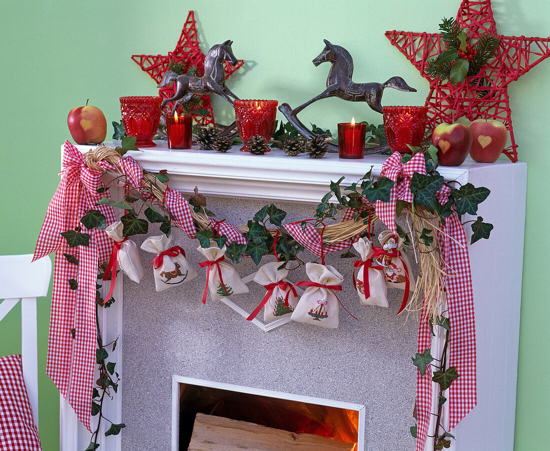 Adventskalender aus kleinen, bestickten Säcken an Girlande aus Bast, Hedera