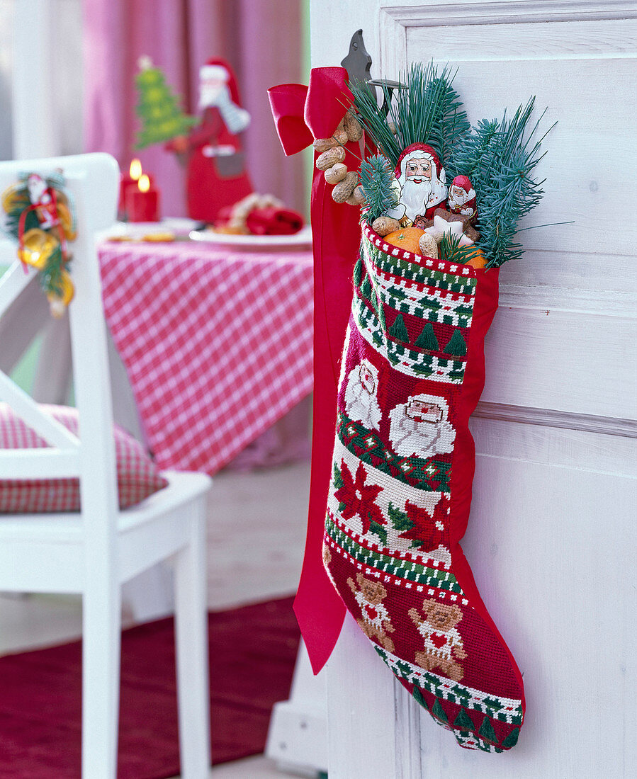 Santa stocking on doorknob filled with abies, pinus