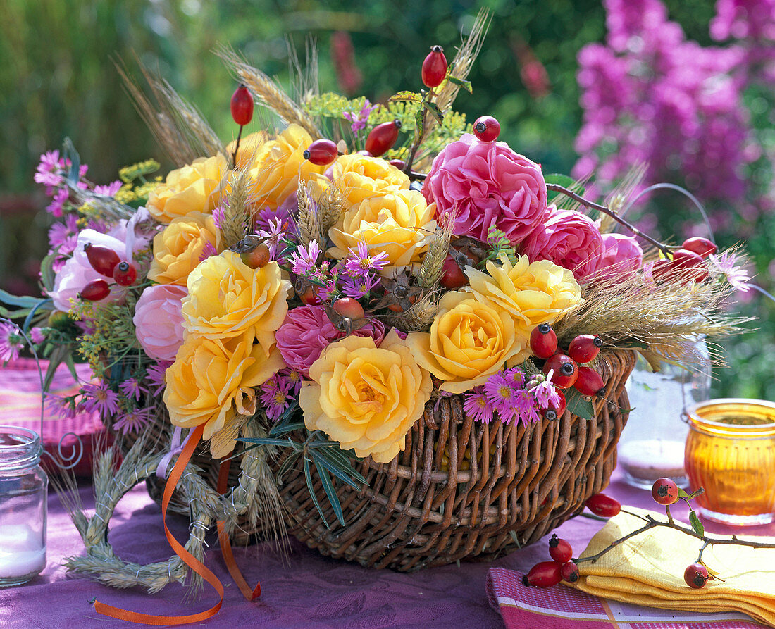 Gesteck aus rosa und gelben Rosa (Rosen und Hagebutten), Secale (Roggen)