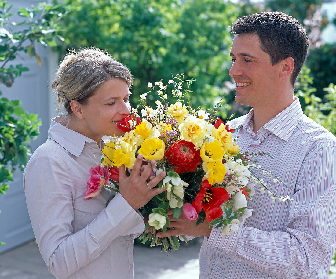 Paar mit Blumenstrauß aus Tulipa (Tulpen), Narcissus