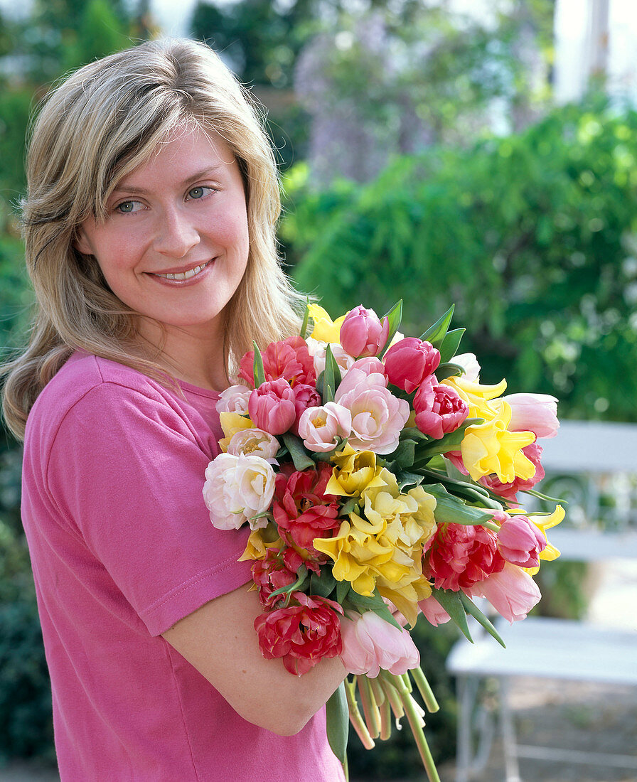 Junge Frau mit Strauß aus Tulipa (Tulpen) rosa, pink und gelb