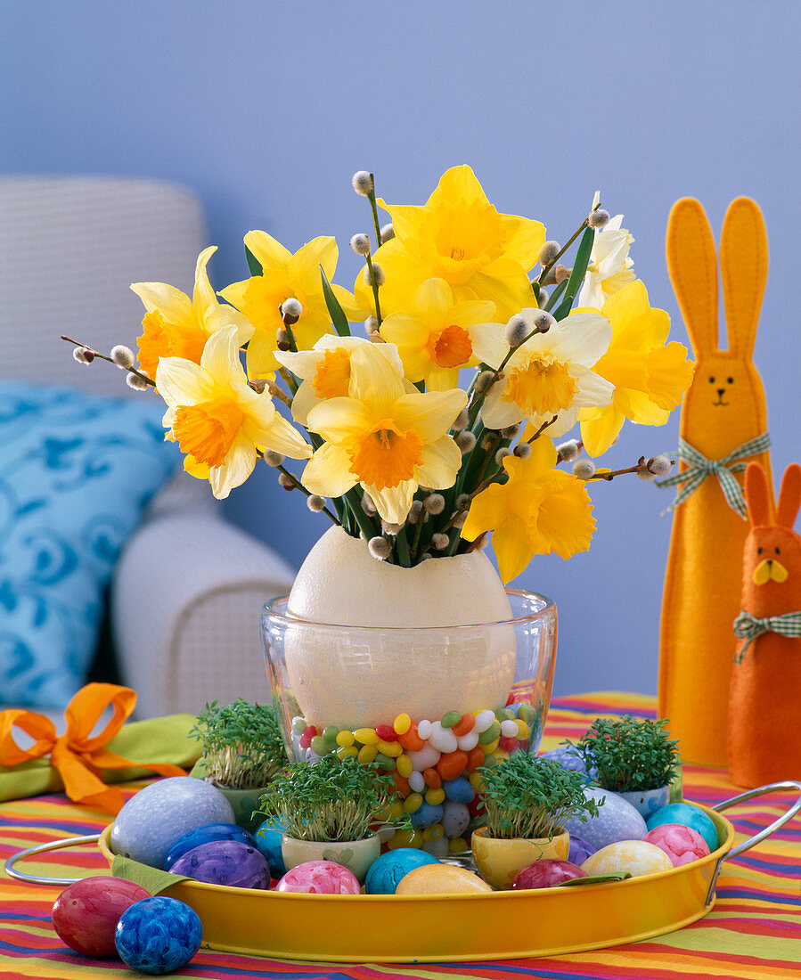 Strauß aus Narcissus (Narzissen) und Salix (Weidenkätzchen) in Eiervase