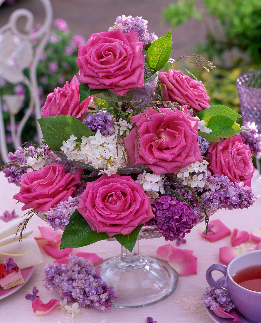 Etagere mit Rosa (Rosen), Syringa (Flieder) und Gräsern