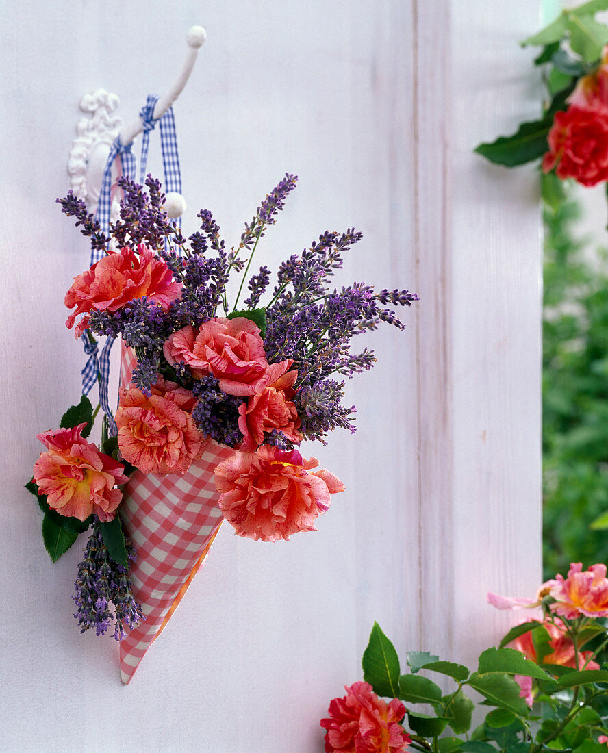 Bouquet of pink and lavandula in checkered bag on hook