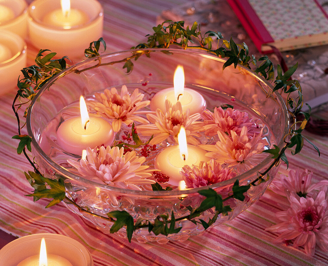 Chrysanthemum and floating candles in glass bowl