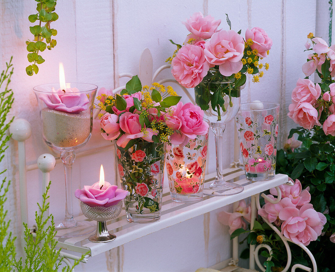Sträuße aus Rosa (Rosen) und Foeniculum (Fenchel) in Gläsern, Kerzen