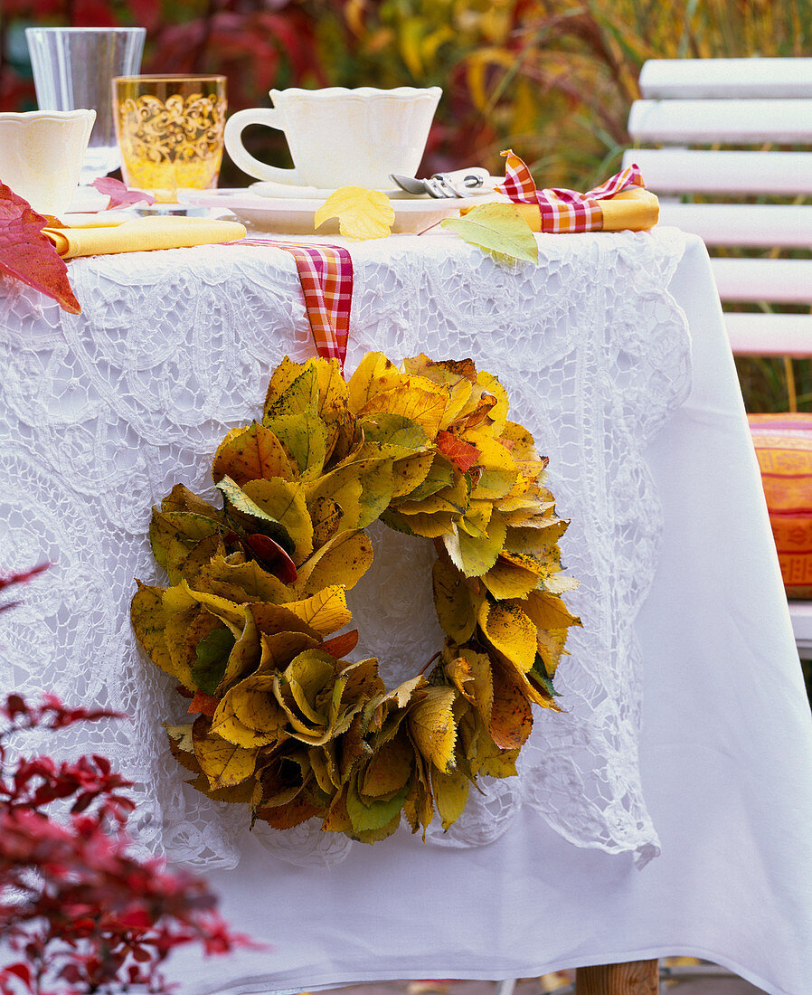 Prunus autumn foliage wreath on the side of a laid table