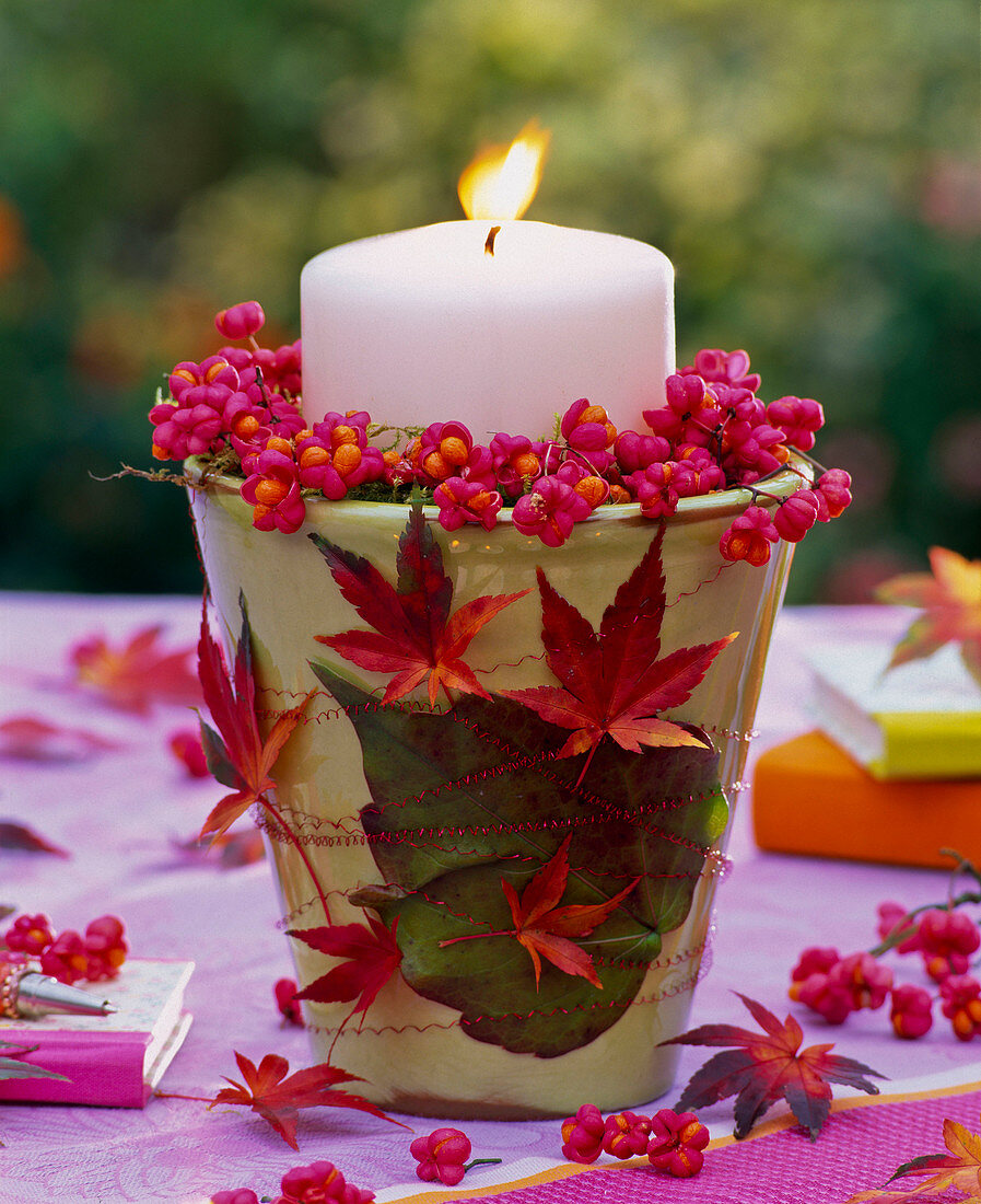 Kerzendekoration mit Euonymus (Pfaffenhütchen) und Herbstlaub von Acer