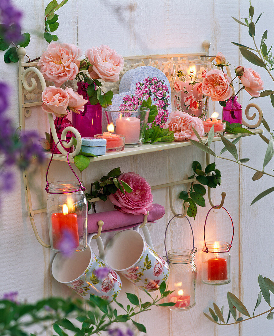 Wandregal dekoriert mit Rosa (Rosen), Tassen, Windlichter, Schachtel mit Rosen