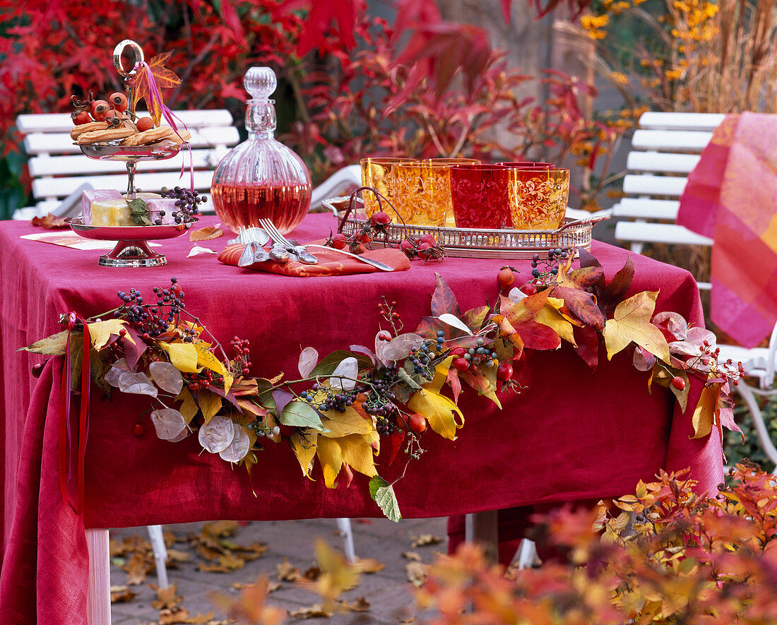 Tischdekoration mit Girlande aus Herbstlaub von Liquidambar (Amberbaum)