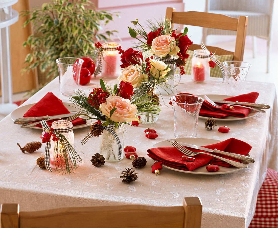 Tischdekoration mit kleinen Sträußen aus Rosa (Rosen), Pinus (Kiefer), Ilex