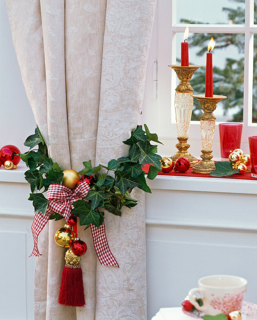 Hedera (Efeu) um Vorhang weihnachtlich dekoriert, Kerzenhalter