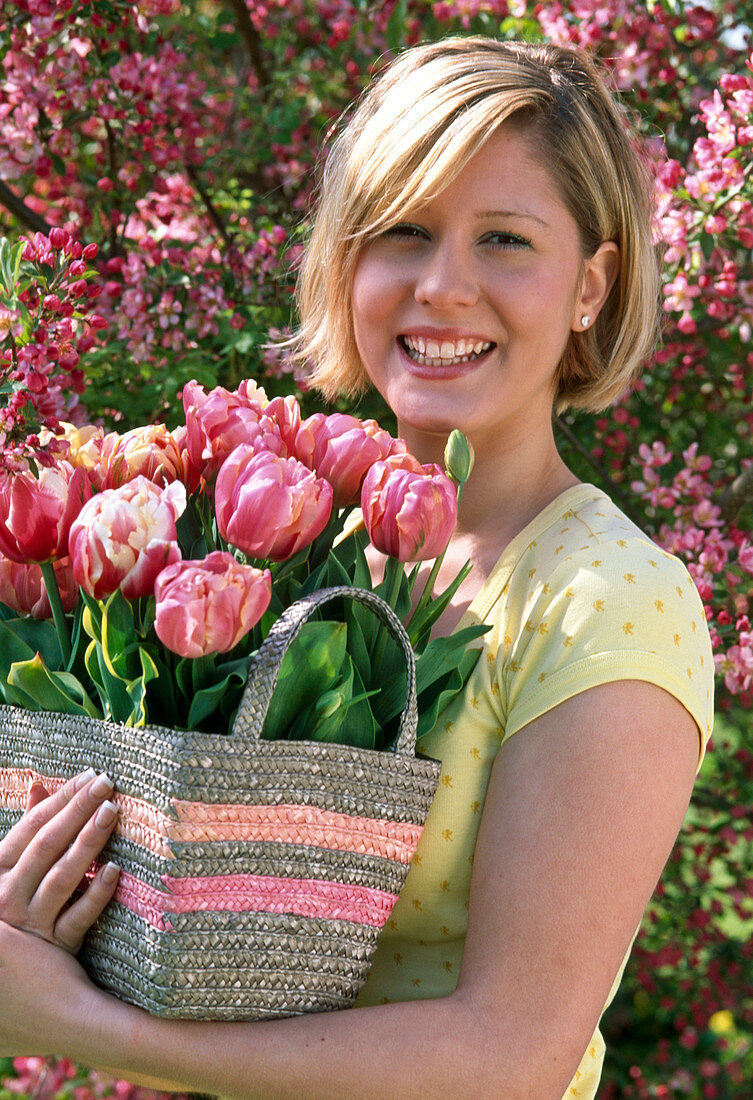 Woman with Tulipa 'Red Sparks', 'Abigail' (tulip) in basket