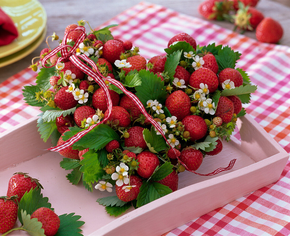 Herz aus Fragaria (Erdbeeren, Früchten, Blättern und Blüten) als Gesteck