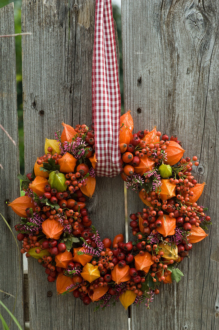Wreath stuck with lanterns and rosehips