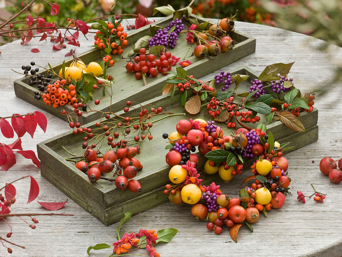 Gesammelte Herbstfrüchte und Beeren in Holzkisten und zum Herz gewickelt