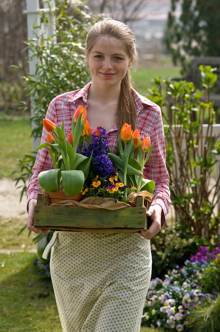 Young woman with Tulipa 'Flair', Hyacinthus 'Kronos'