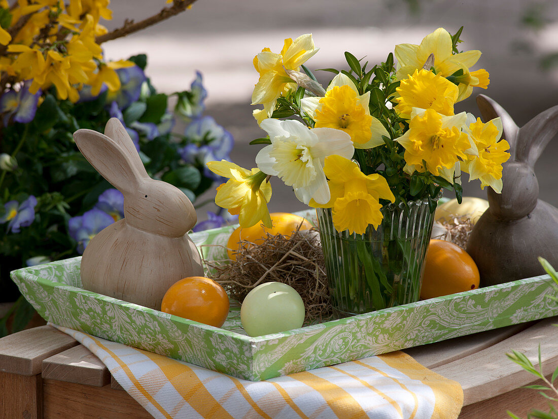 Small bouquet of narcissus on tray with Easter bunnies
