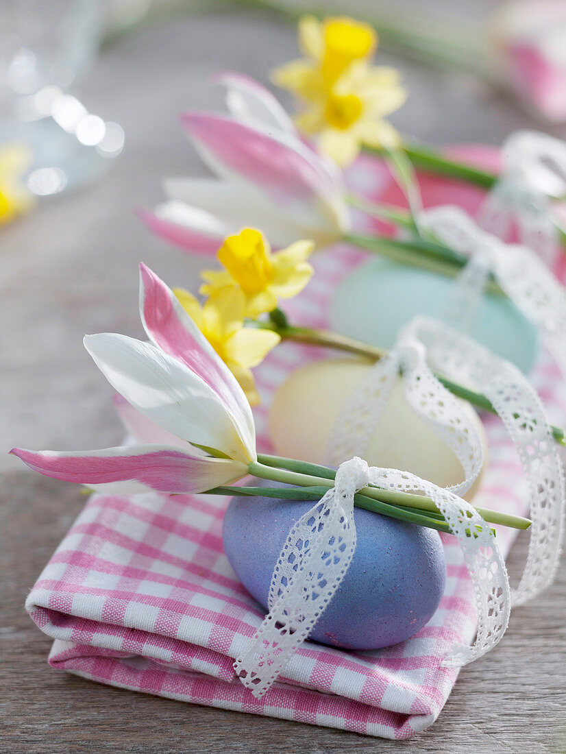 Eggs dyed with natural colors decorated with lace ribbon and flowers