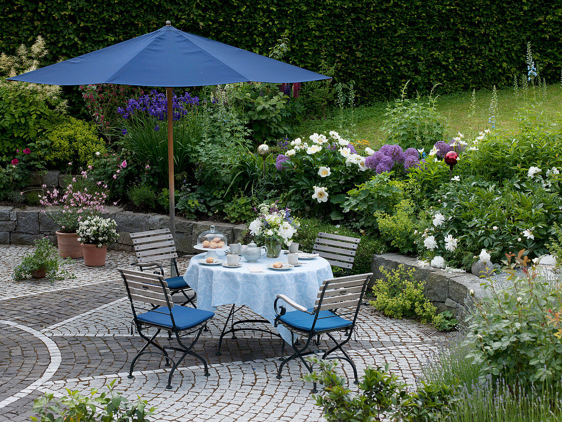 Seating with table laid under blue parasol