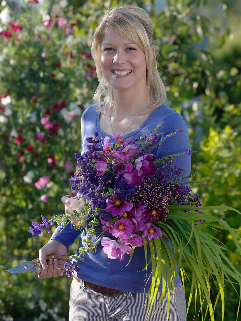 Junge Frau mit frisch geschnittenen Cosmos (Schmuckkörbchen)