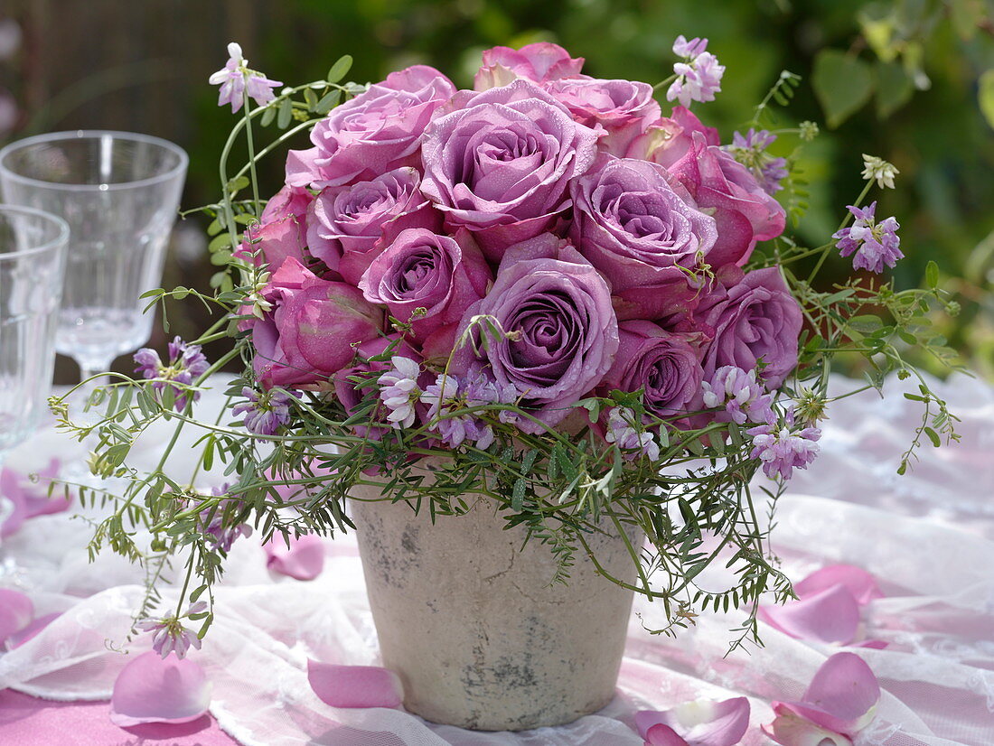 Bouquet of purple, fragrant roses with crown vines from the meadow