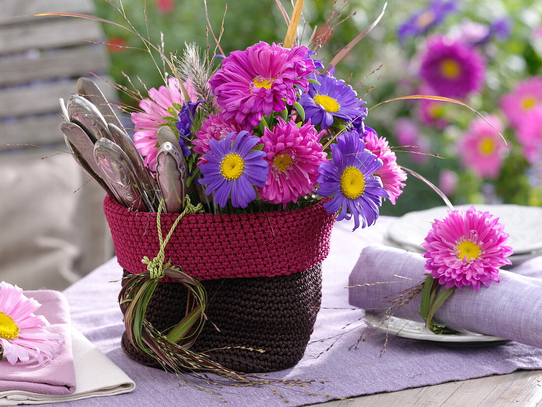 Small crocheted basket with summer asters and cutlery