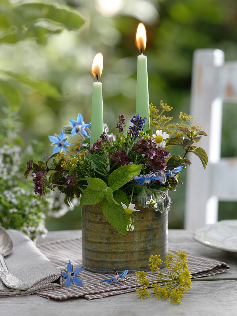 Candle arrangement with herbs in metal pot