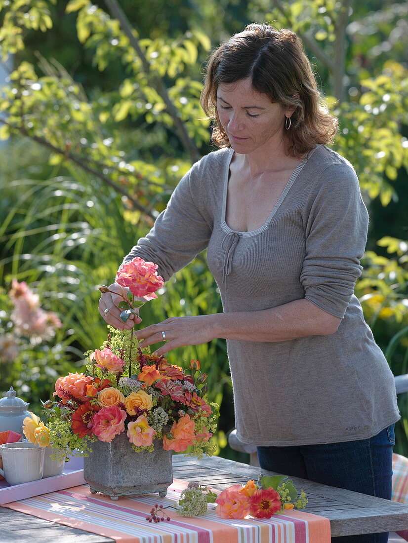 Woman inserts late summer bouquet