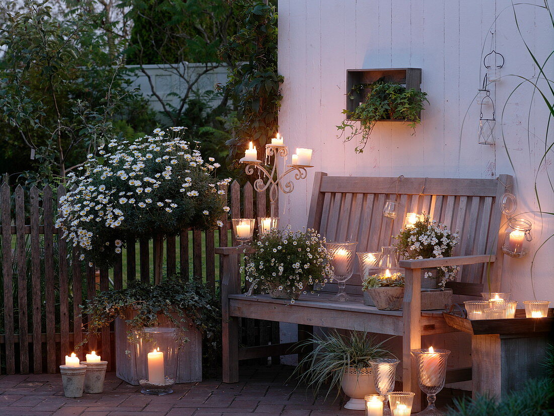 weiße Abendterrasse mit Windlichtern und Kerzen