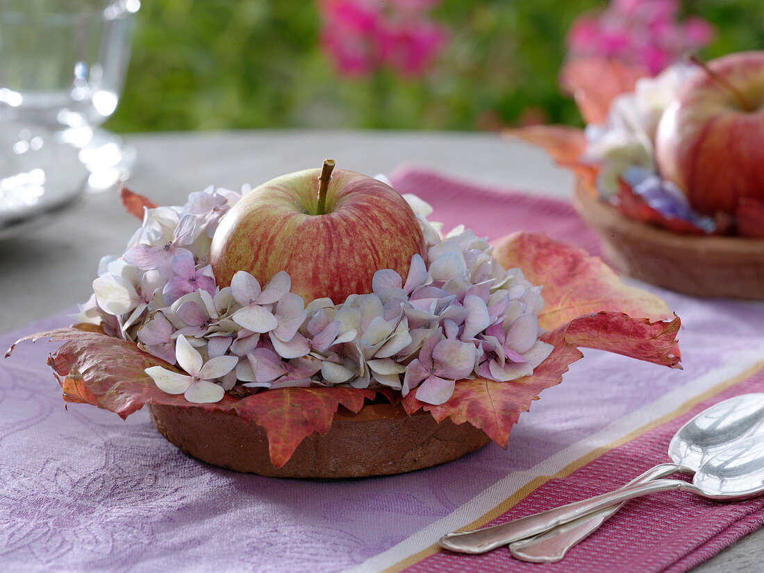 Kleine Tischdekoration mit Apfel und Hortensienblüten