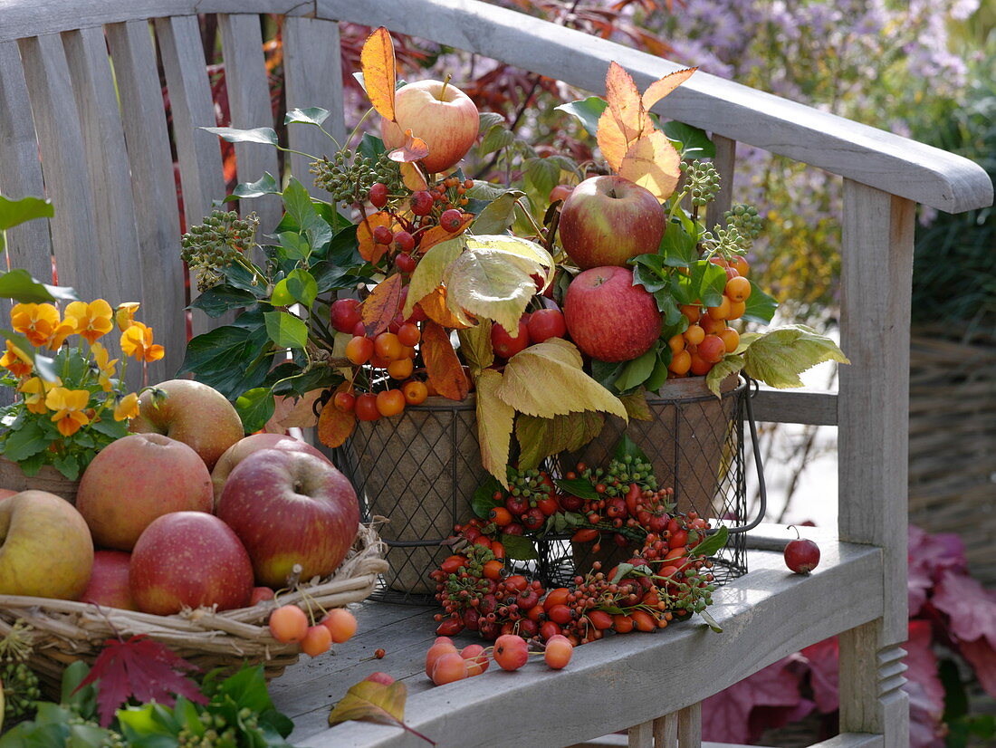 Herbstliches Gesteck mit Äpfeln, Zieräpfeln, Hagebutten und Efeu