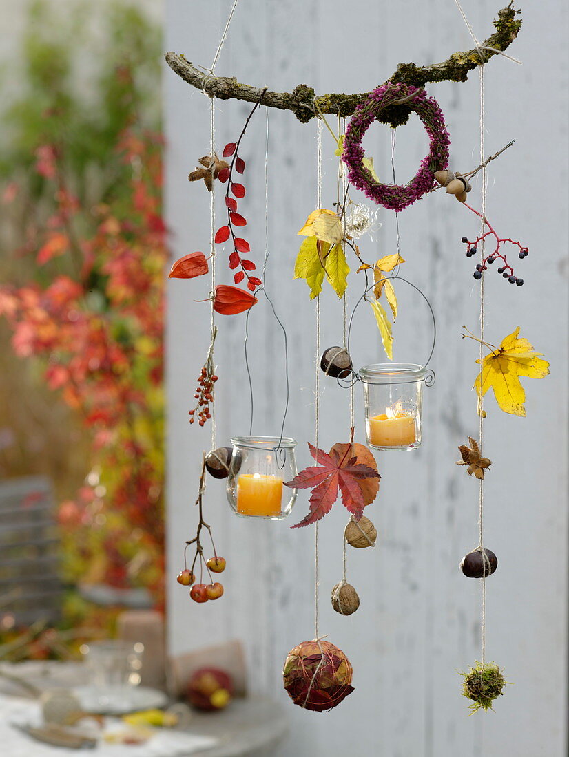 Autumn mobile made of twigs, leaves, fruits with lanterns