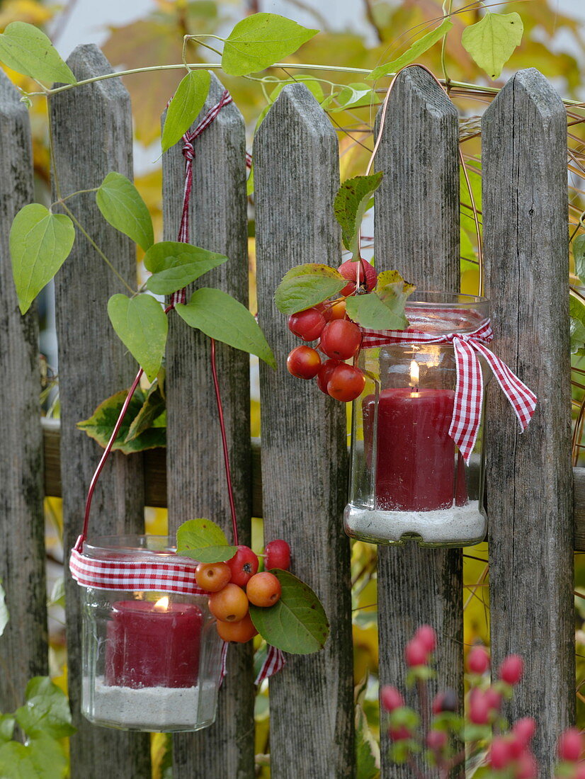 Lanterns made of jam jars with red candles and bird sand