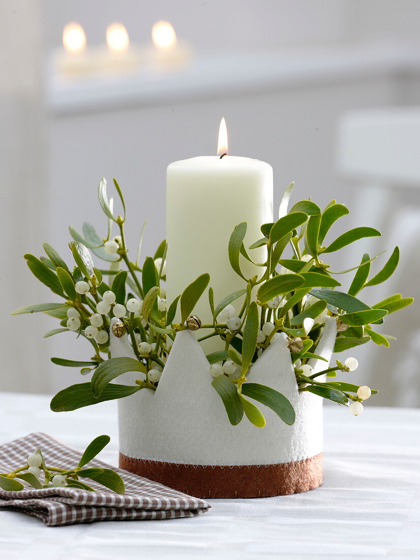 Candle arrangement in felt crown white candle with Viscum album