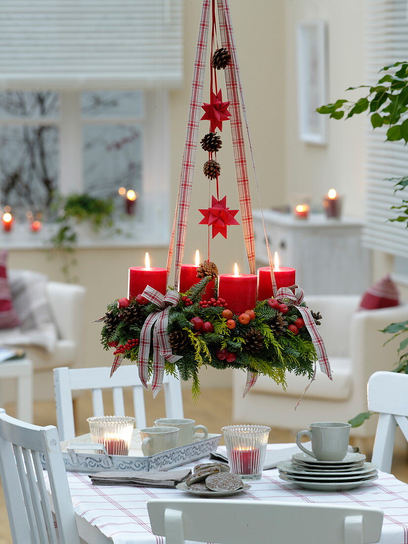 Mixed Christmas wreath with red candles hung over the table