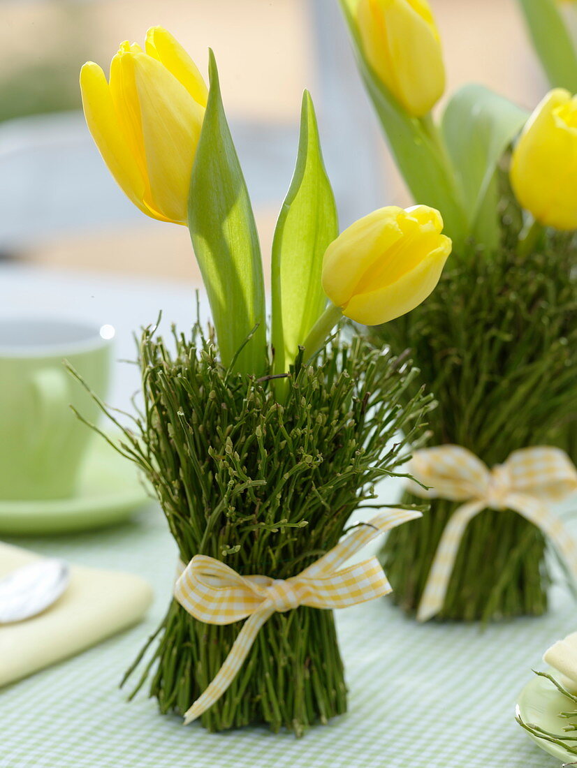 Table decoration with yellow tulips and blueberry branches