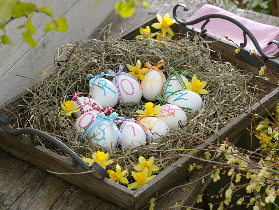 Easter basket of hay on wooden tray