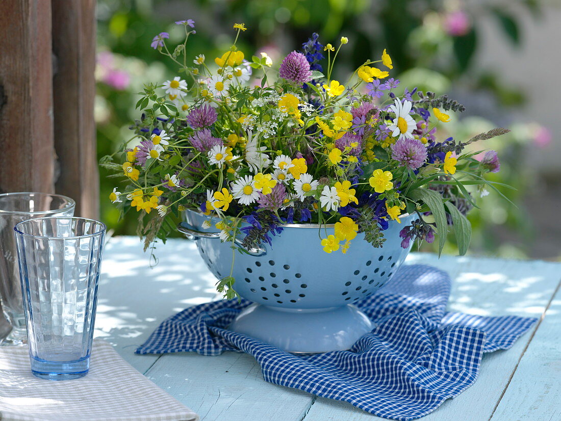 Meadow bouquet in cup in enameled colander