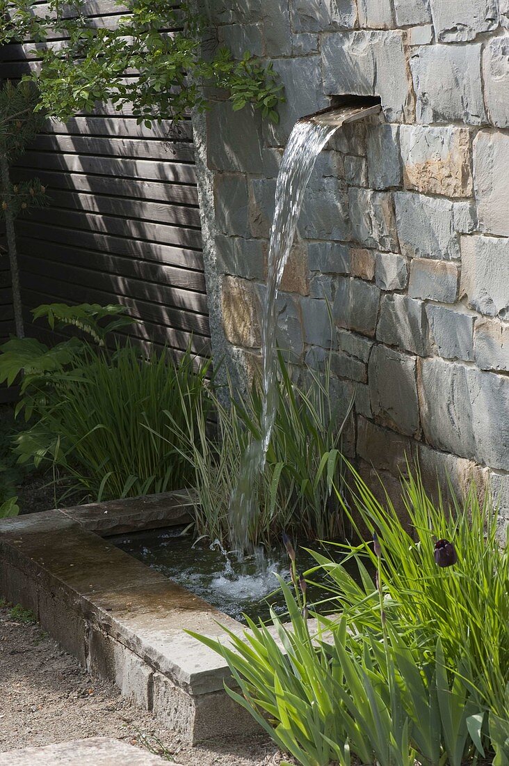 Natural stone wall with integrated waterfall