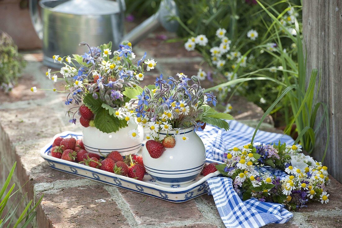 Small bouquets made of flowering herbs and freshly picked strawberries