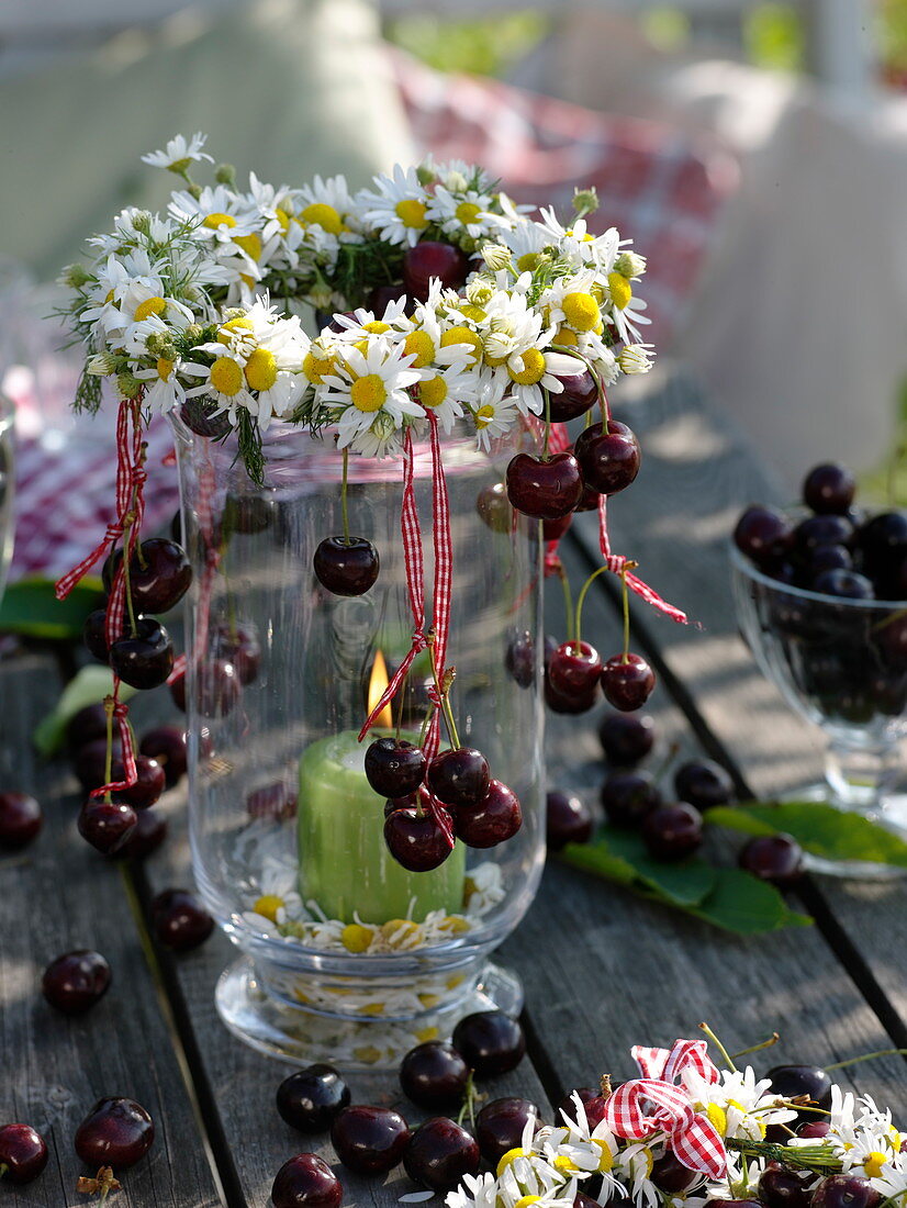 Summery table decoration with sweet cherries and chamomile