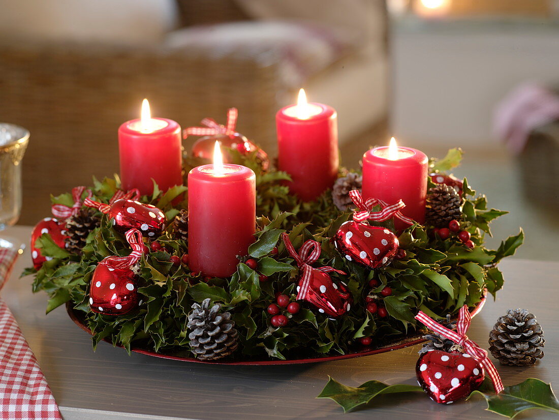 Advent wreath of ilex decorated with red hearts and cones
