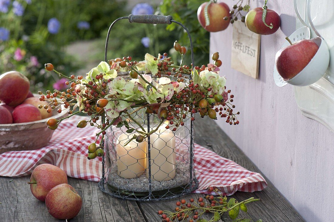 Glass lantern in wire basket with hydrangea and roses wreath