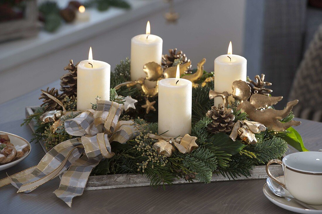 Weiß-goldener Adventskranz mit weißen Kerzen
