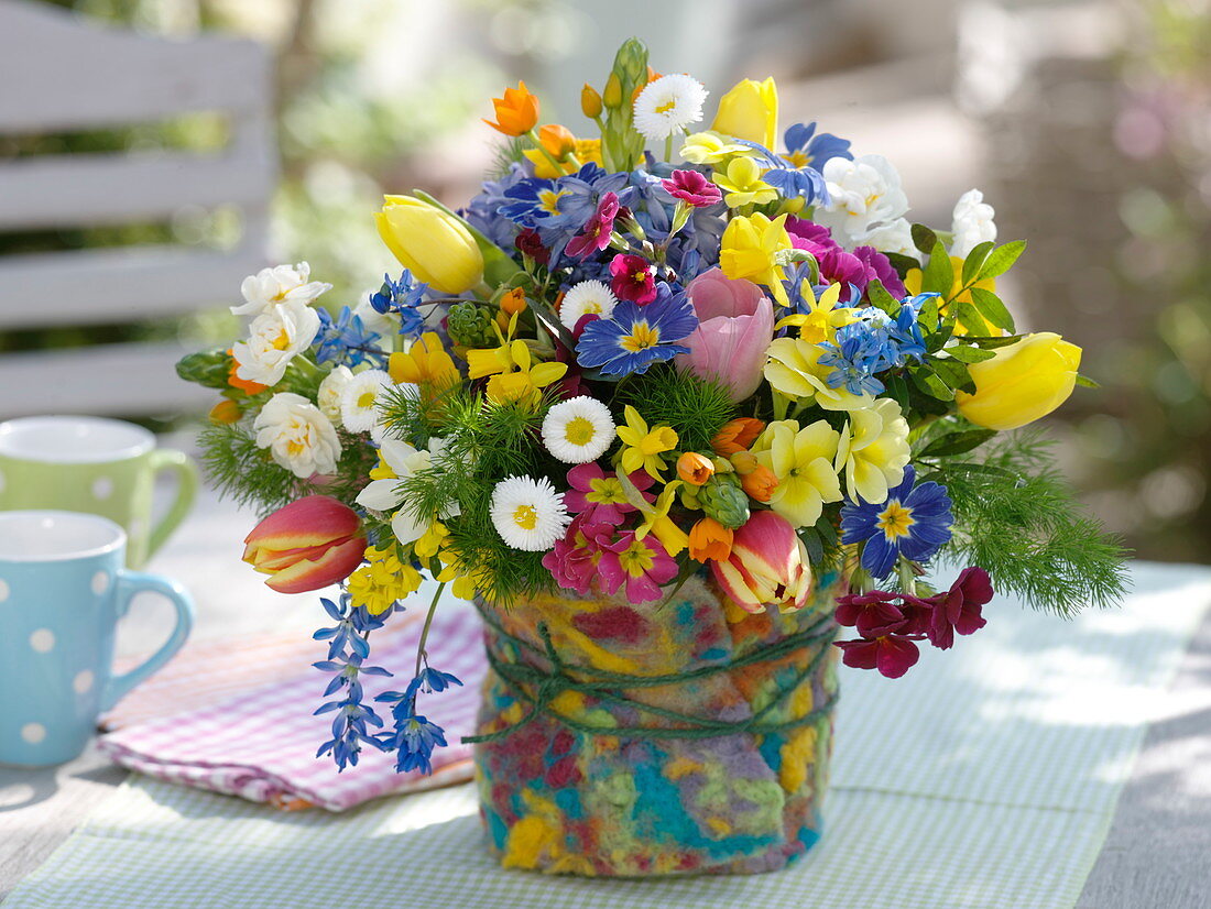 Colorful spring bouquet in vase with felt cover