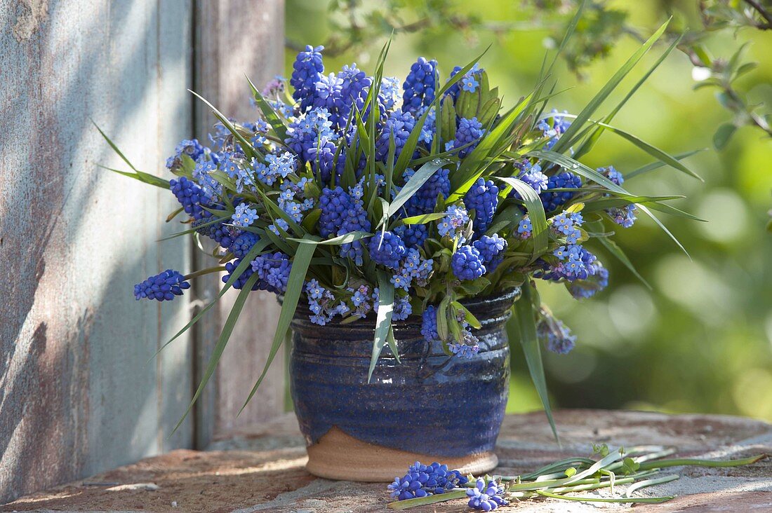 Blauer Frühlingsstrauß in rustikaler Vase