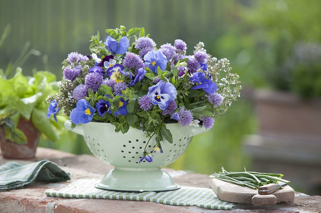 Edible arrangement in a colander, flowers of chive