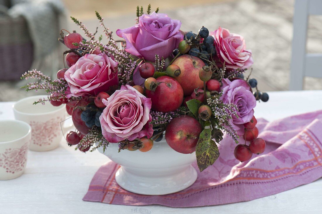 Herbstlicher Strauss mit Rosa (Rosen), Äpfeln und Zieräpfeln (Malus)